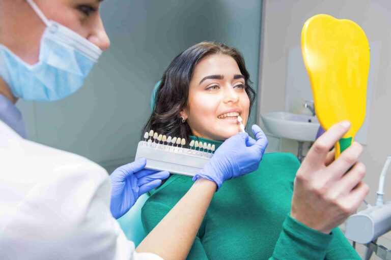 Dentist showing a patient a tooth shade guide during a cosmetic dental consultation.